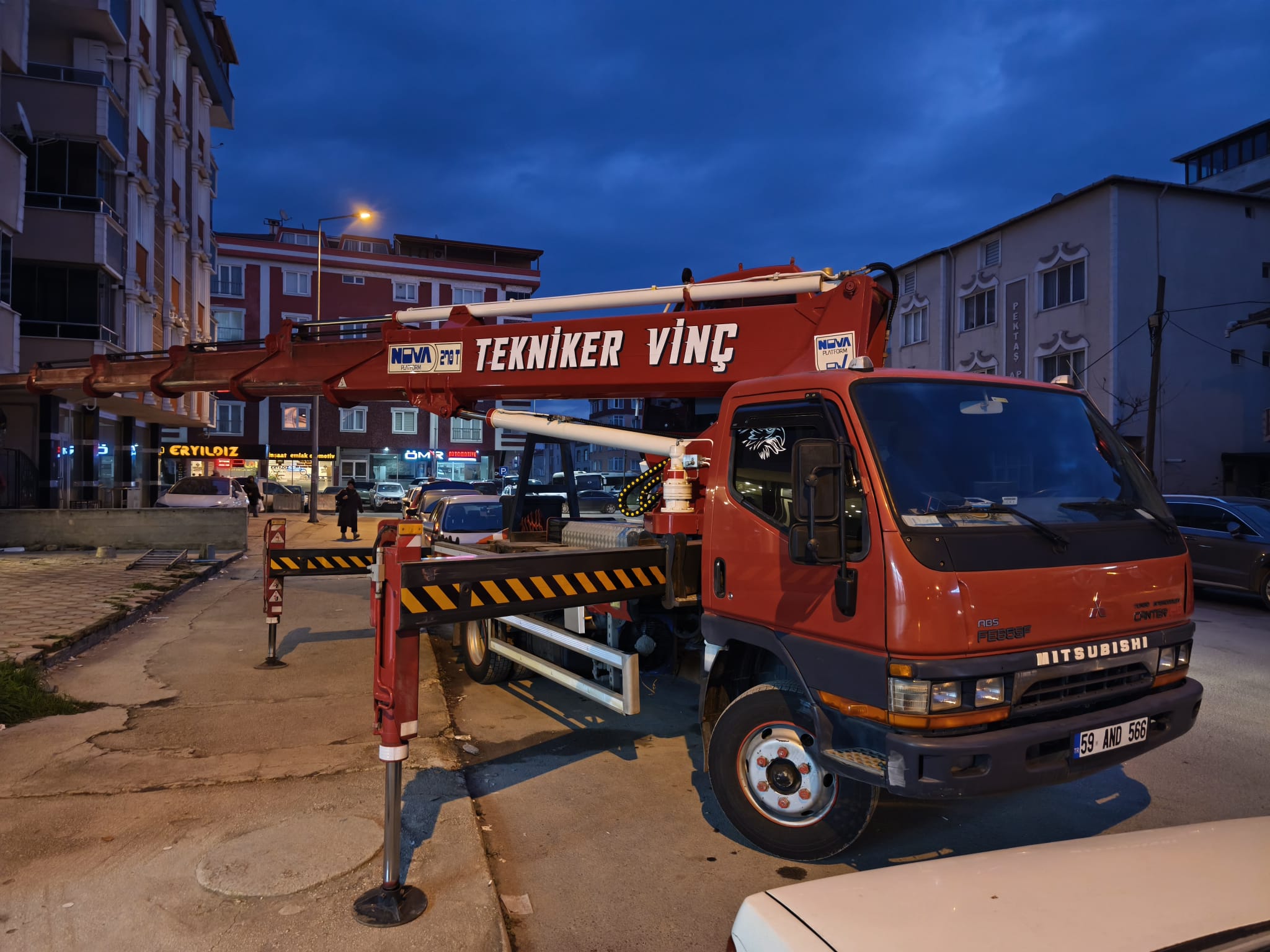 Akşam saatlerinde destek ayakları açık kırmızı vinç