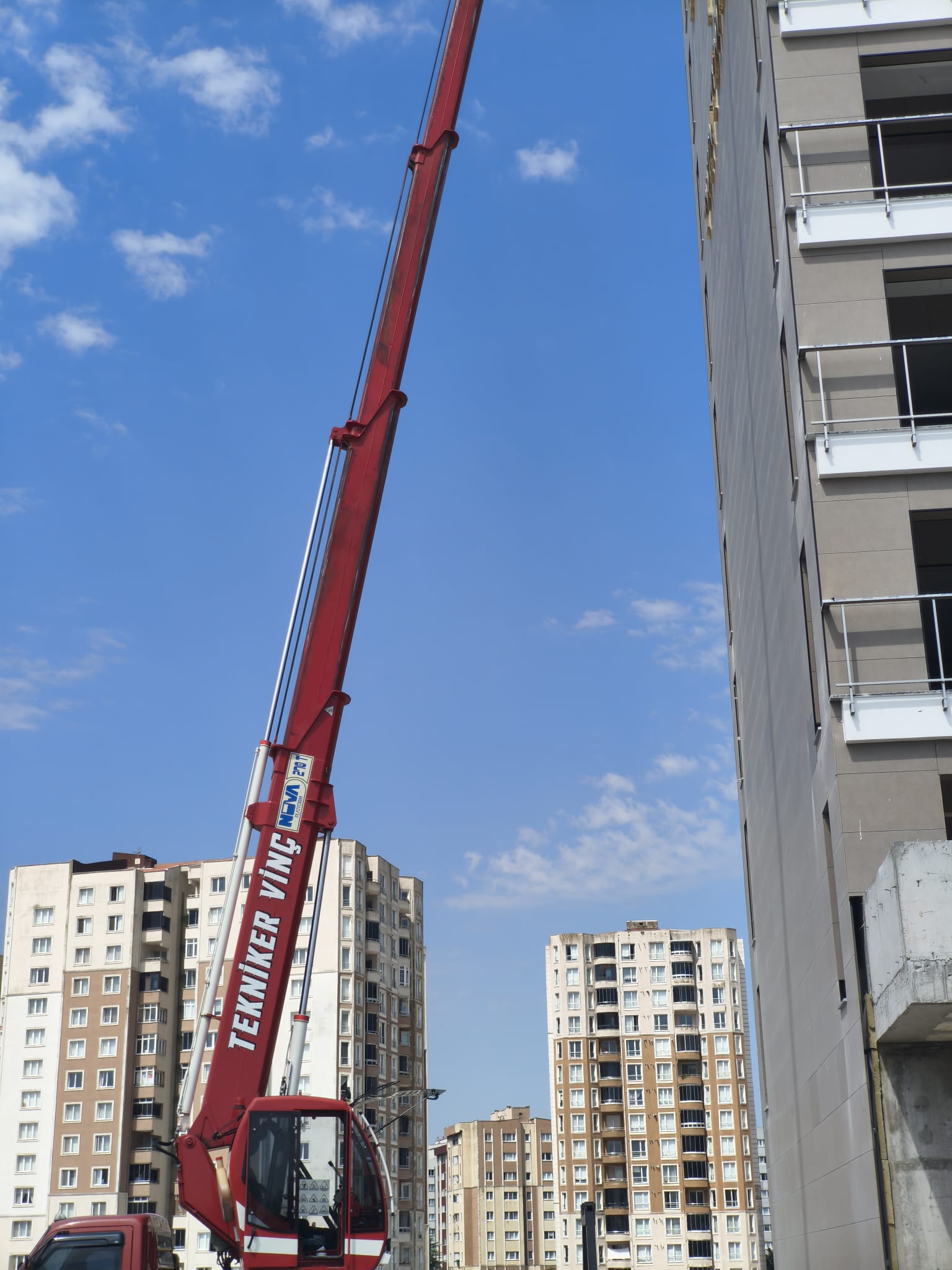 Apartman yanında yükseltilmiş teleskopik vinç kolu