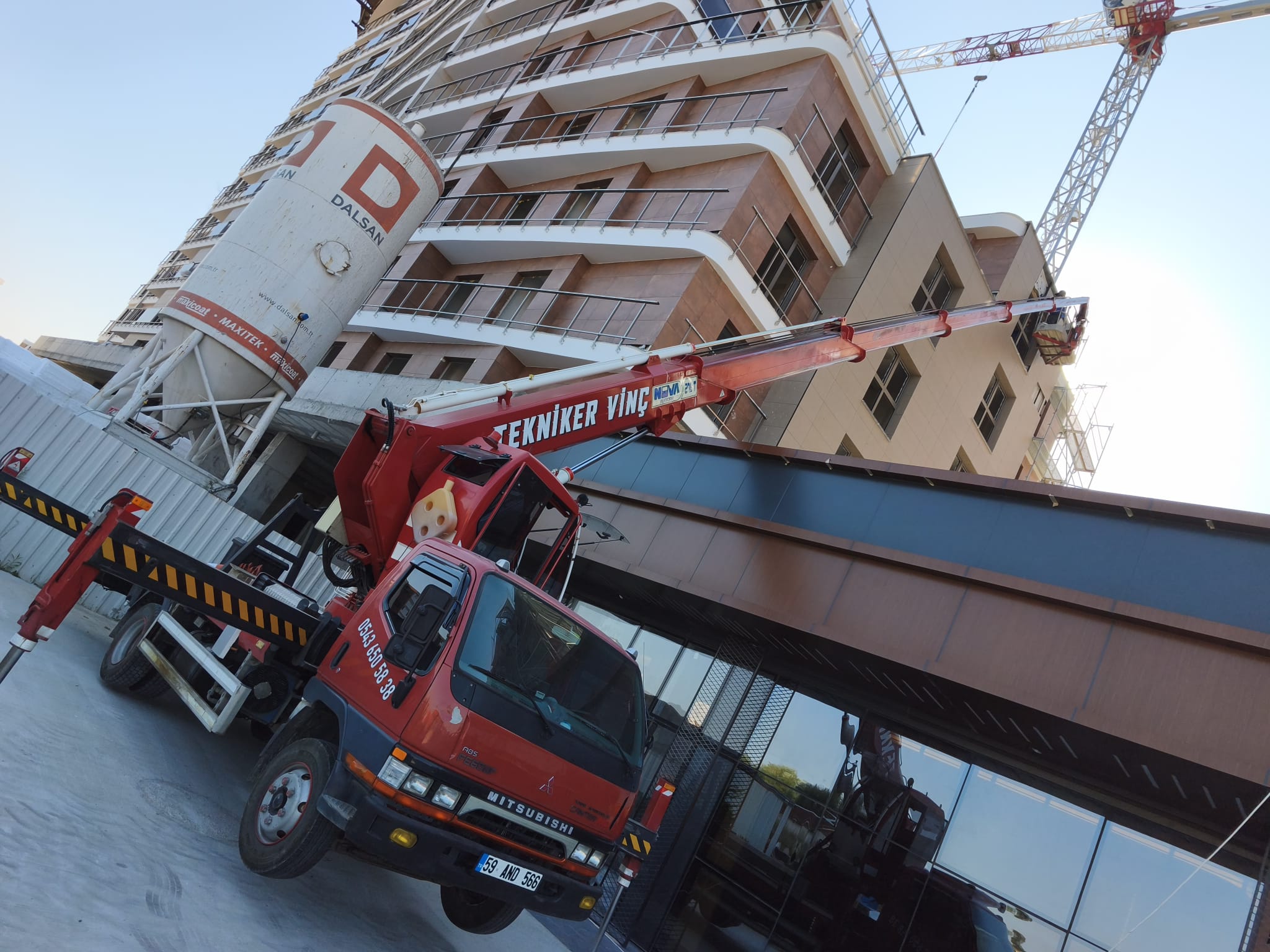 Çok katlı bina inşaatında sepetli vinç