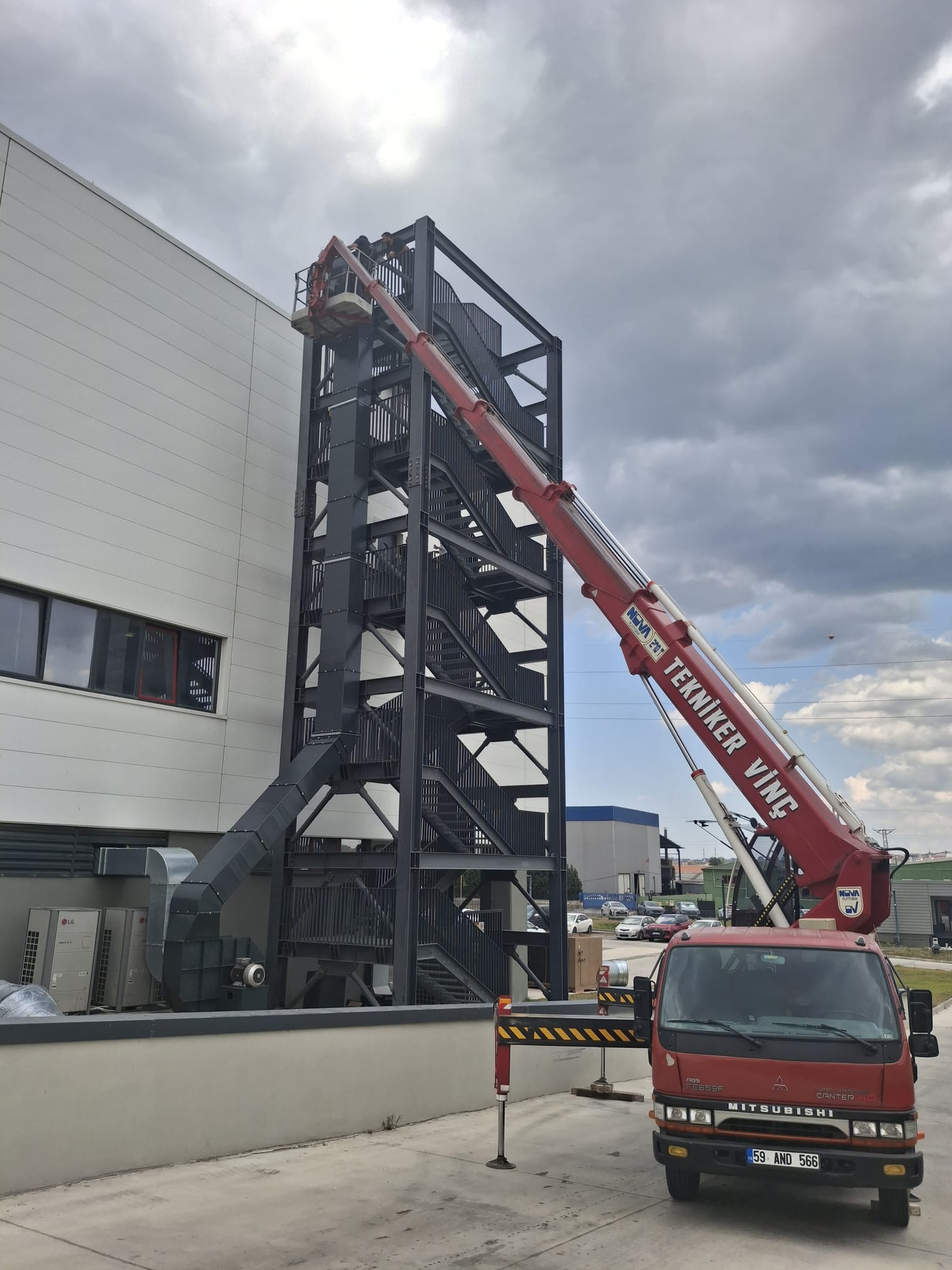 Fabrika çelik kulesinde sepetli vinç çalışması