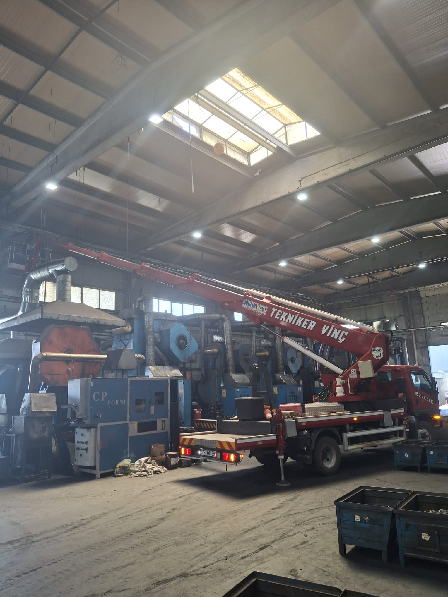 Fabrika makineleri arasında kamyon üstü vinç