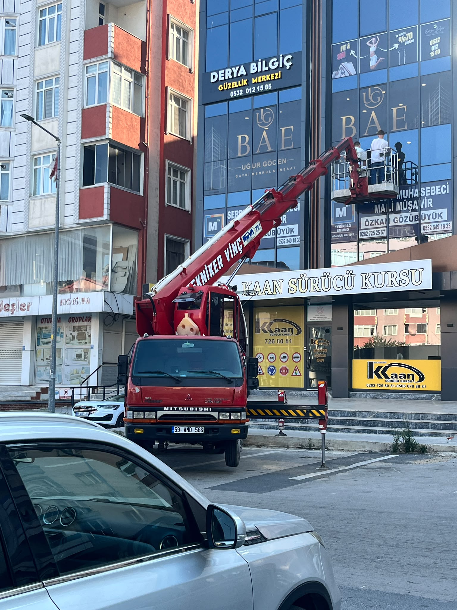 İş merkezi reklam tabelasında sepetli vinç çalışması