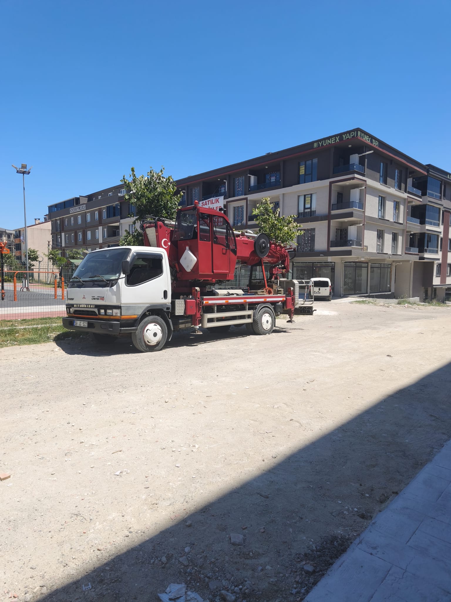 Konutların önünde park halindeki beyaz kamyonlu vinç