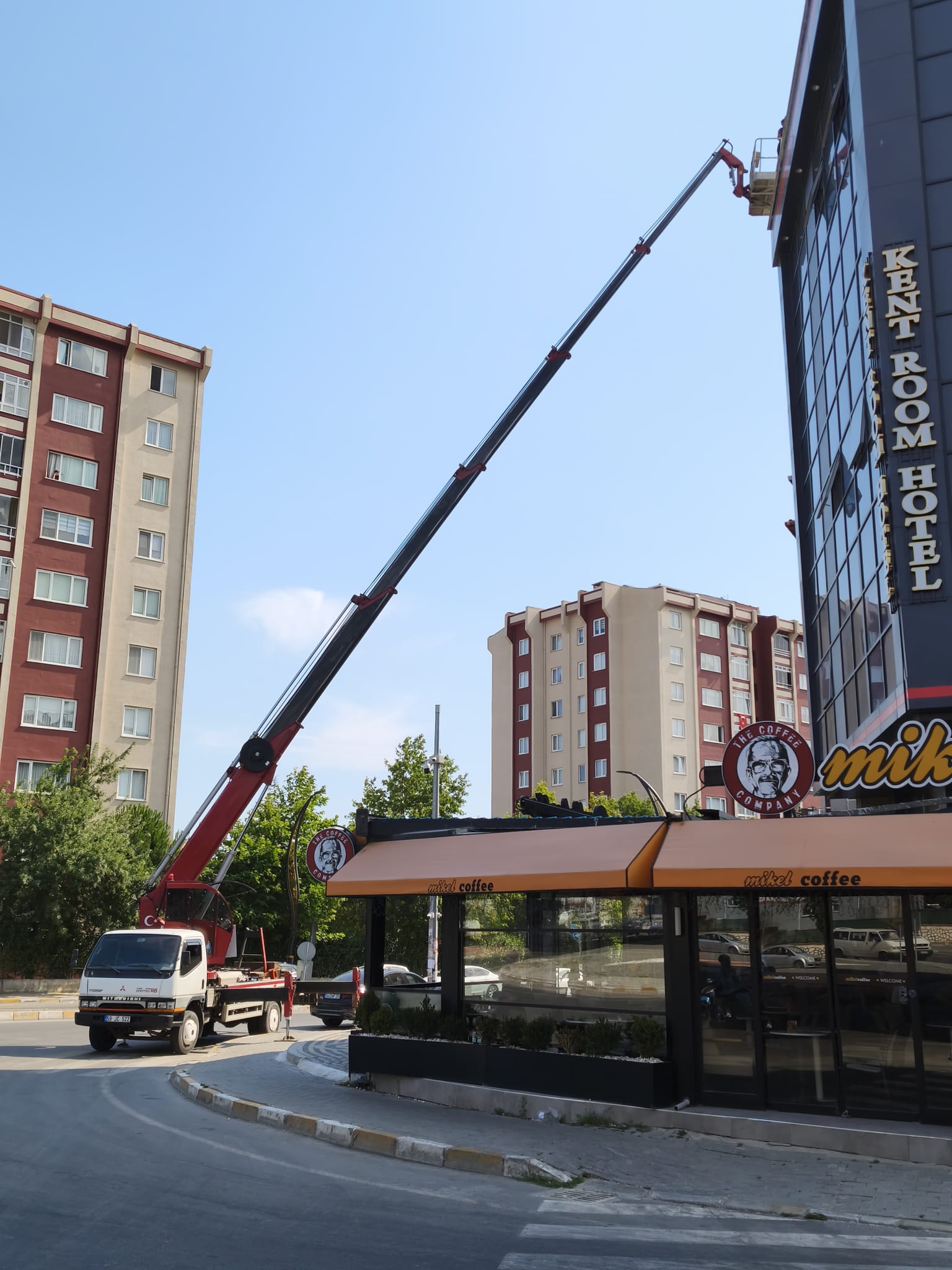 Köşe başındaki cam binaya uzanan sepetli vinç
