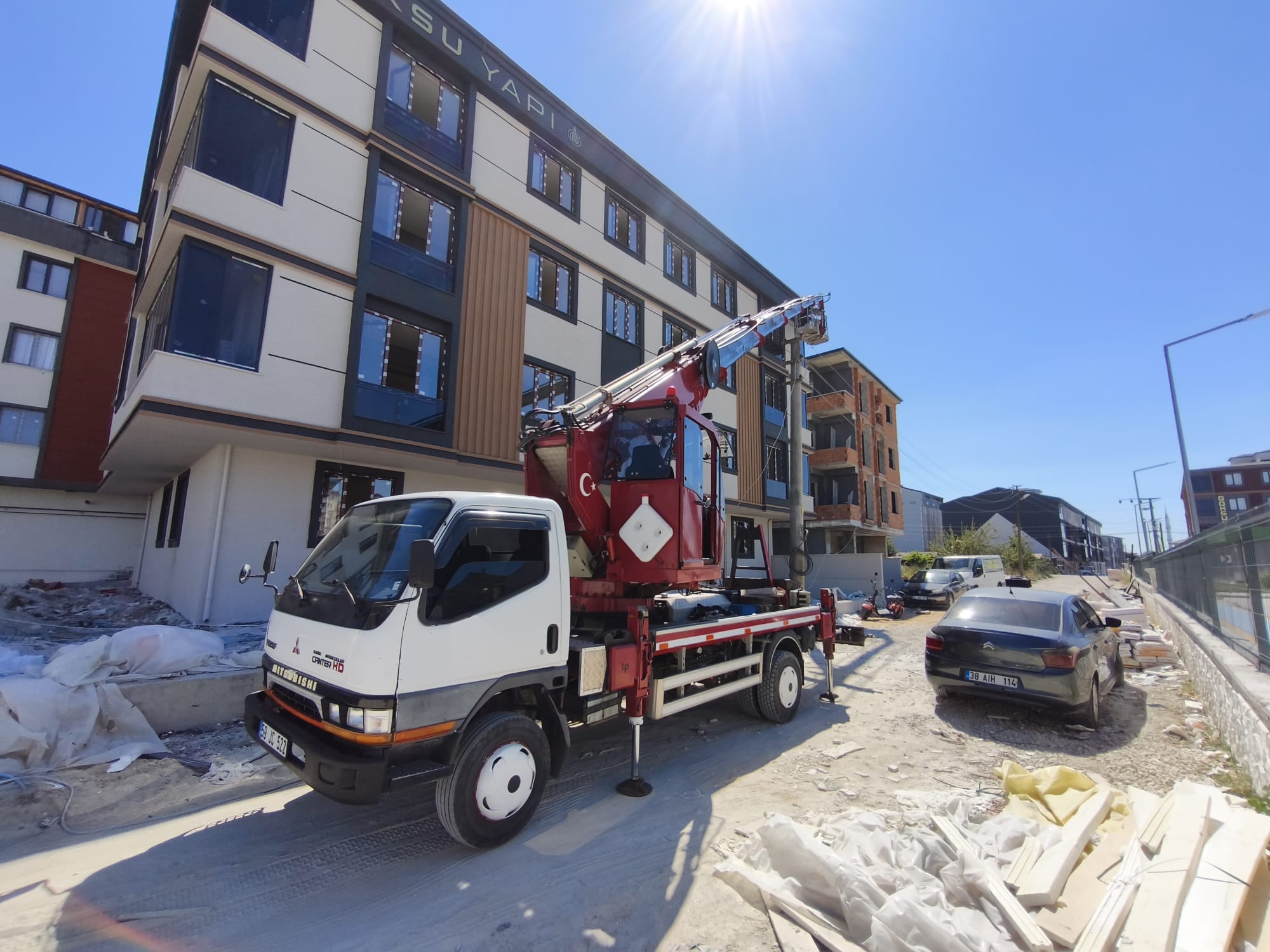 Yeni apartman önünde destek ayakları açık vinç