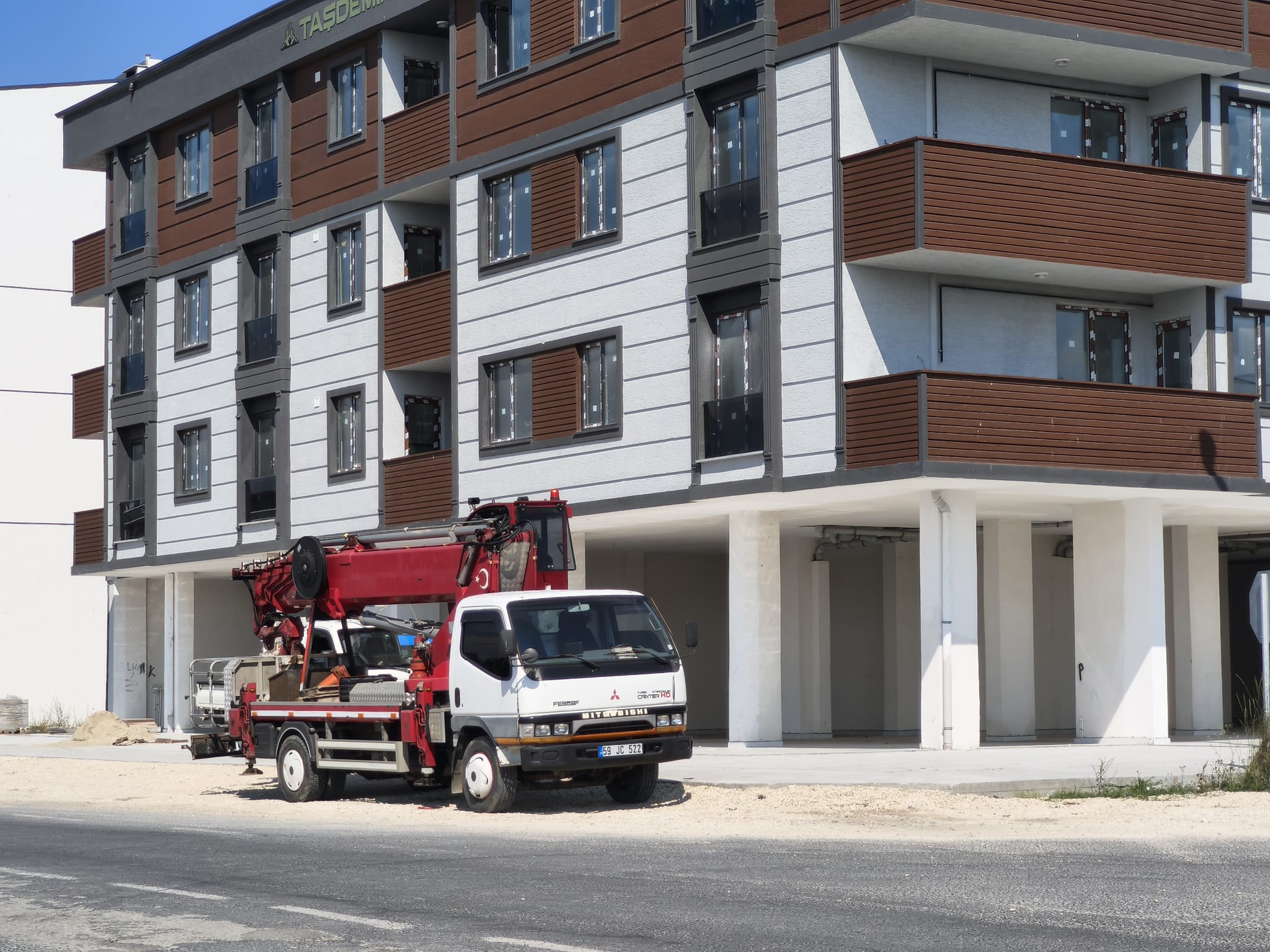 Yeni apartman önünde katlanmış kamyon üstü vinç
